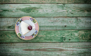Cake on plate on green rustic background. Top view