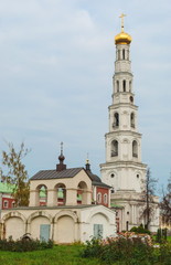 Fototapeta na wymiar The chapel and bell tower Ugresha Monastery in Moscow region overcast autumn day