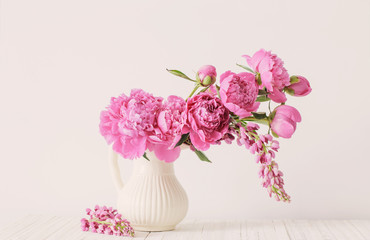Peony flowers in vase on white background