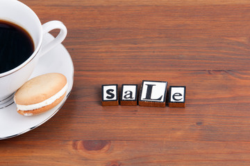 Coffee cup on a wooden table and text - Sale