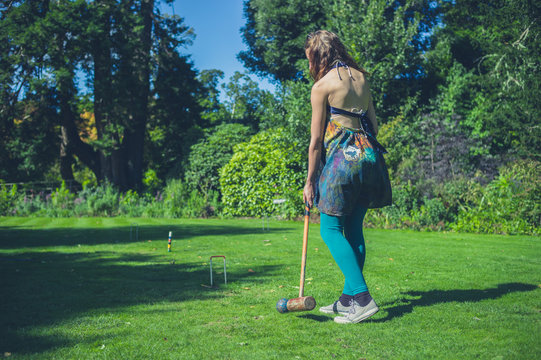 Young woman playing croquet