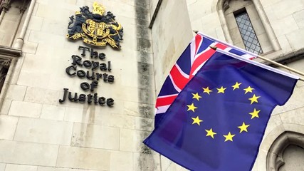 EU and Union Jack flags flying in front of The Royal Courts of Justice public building in London, UK