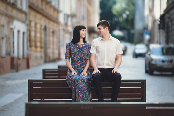 Fototapeta premium Sweet couple is sitting on the wooden bench