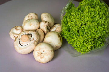 raw and fresh mushrooms and lettuce on the table