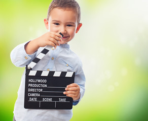 portrait of a little boy holding a clapper board