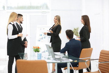 Colleagues asking a question to a businesswoman during a present