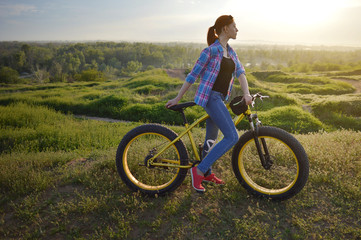 Obraz premium Girl on a bicycle in the sunset