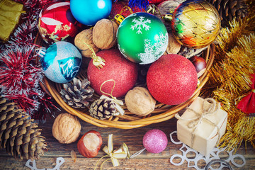 Christmas Composition with Gifts. Basket, red balls, pine cones, snowflakes on Wooden Table. Vintage style