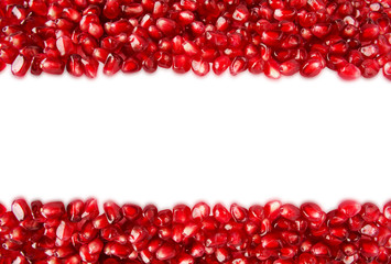 Background made of red pomegranate seeds. The scattered red grains of a pomegranate. Top view.