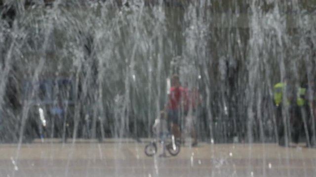 people at the fountain, images is blurred, no recognizable people