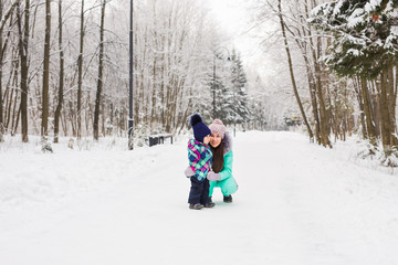 Mother and child girl on a winter walk in nature. Happy family