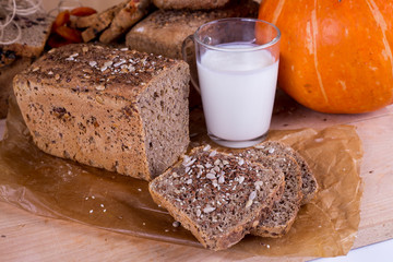 a loaf of bread on the background of cutting boards and other bread and pumpkin,