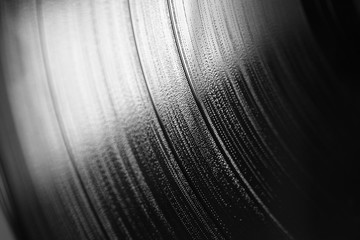 Macro di fianco di un disco musicale in vinile in bianco e nero con un riflesso di luce bianca in...