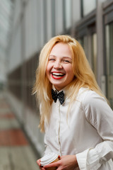 Ginger girl with bow tie on shirt laughing in lobby