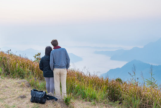 view of a loving romantic couple standing on top mountain to can