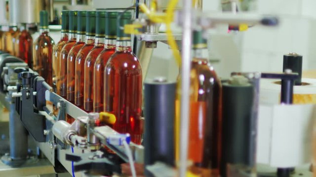 Automated conveyor line in inodelne. Place labels on bottles of wine. Industrial Automation