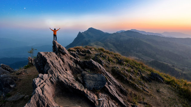 Winner man on peak of rocks mountain Hike at sunset, Active life
