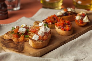 Hot sandwiches with tomatoes and cheese on a wooden tray
