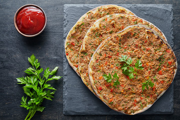 Lahmacun traditional turkish pizza with minced beef or lamb meat, paprika tomatoes, parsley baked...