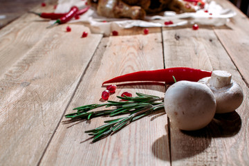 Mushrooms, red hot pepper, rosemary and berries pomegranate are on the wooden table