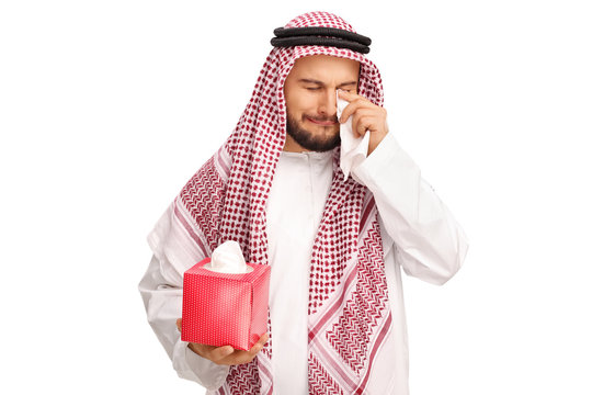 Upset Arabian man crying and wiping his tears with napkins