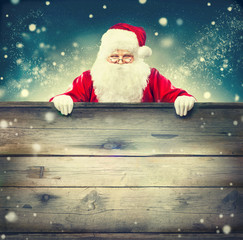 Happy Santa Claus holding wooden banner background. Christmas theme