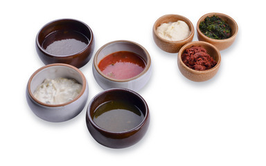 Six cups and saucers with various sauces