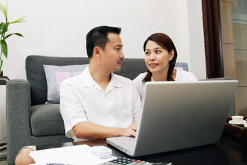 Couple in living room, with laptop