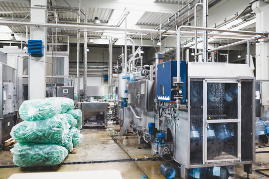 Industrial interiors and machinery. Robotic factory line for processing and quality control of pure spring water bottled into canisters.