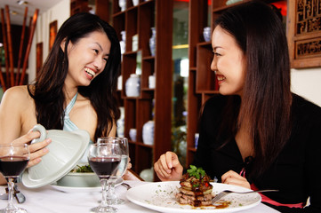 Women in restaurant, sitting at table with food