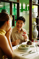 Couple in restaurant, man proposing with ring