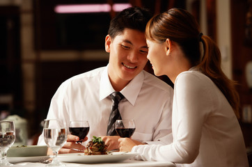 Couple in restaurant, sitting side by side