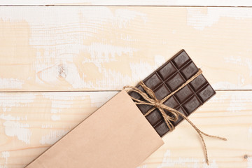 Dark chocolate bar on vintage wooden background
