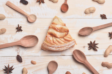 Fototapeta na wymiar Slice of apple pie on vintage wooden background