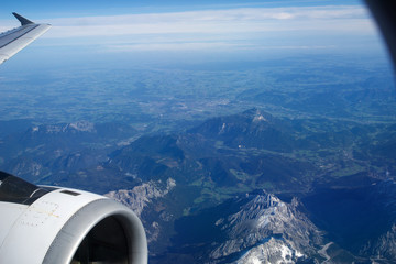 Naklejka na ściany i meble AUSTRIA - October 2016: The alps as seen from an airplane, wing view with plane turbine or engine.