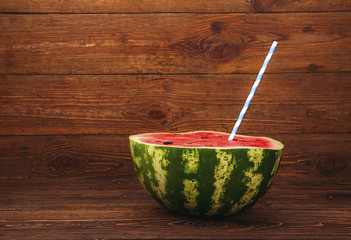 cut juicy watermelon with a striped straw