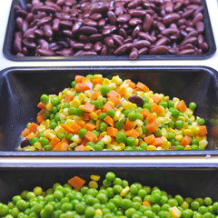 Various vegetables mixed on salad bar.