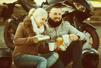 Fototapeta na wymiar Couple drinking coffee near motorcycle