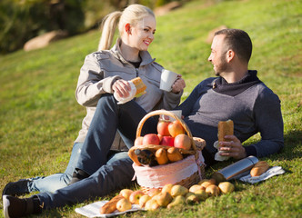 Loving happy young couple chatting as having picnic