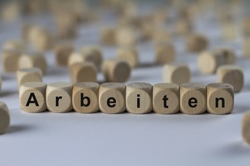 Fototapeta premium Arbeiten - Holzwürfel mit Buchstaben