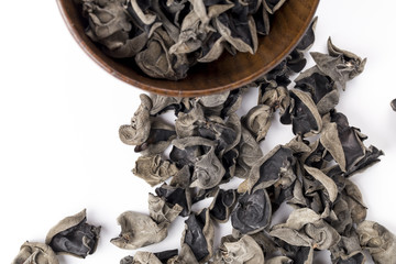 Black fungus in a wooden bowl on the white background