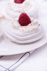 Meringue nest with whipped cream and raspberry  close up, room f