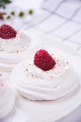 Meringue nest with whipped cream and raspberry  close up, a lot