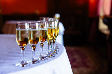 Beautiful line of champagne glasses. decorated bouquet with kitchen, table at the event in the restaurant