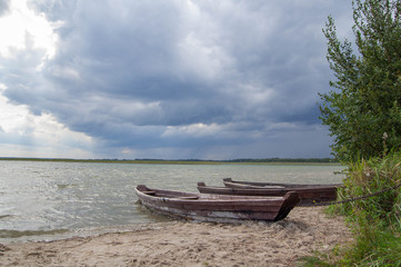 Naklejka na ściany i meble Two boats on the lake with storm clouds over them.