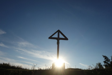 Sign of faith. Wooden cross in a cloudy sky.