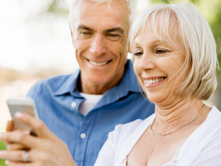 Happy senior couple looking at smartphone