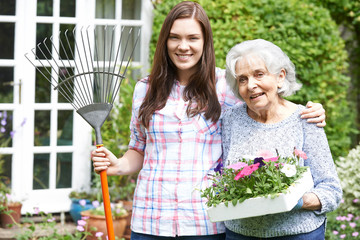 Teenage Granddaughter Helping Grandmother In Garden