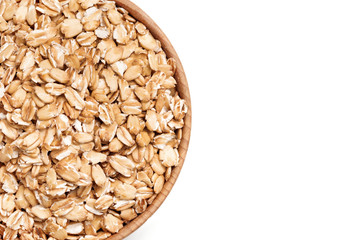 Uncooked oat flakes in wooden bowl on white background. Healthy food. Close up, top view, copy cpace, high resolution product