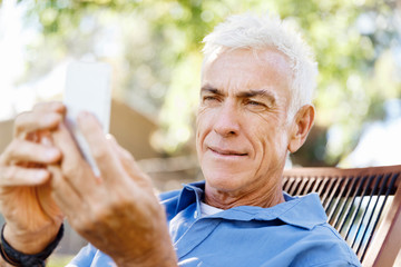 LoMature man outdoors using mobile phone